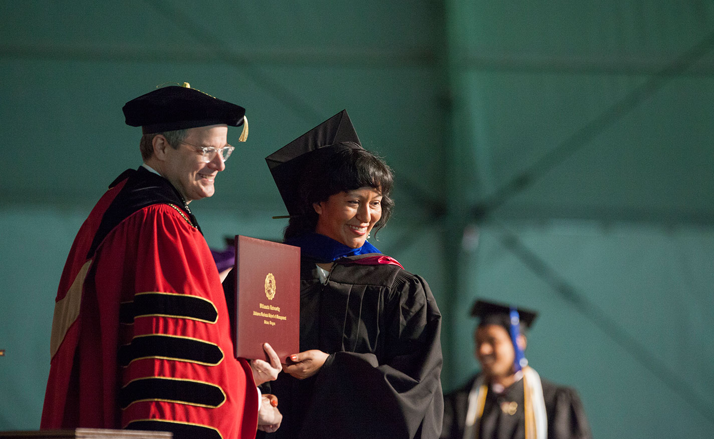 President Thorsett awards a diploma