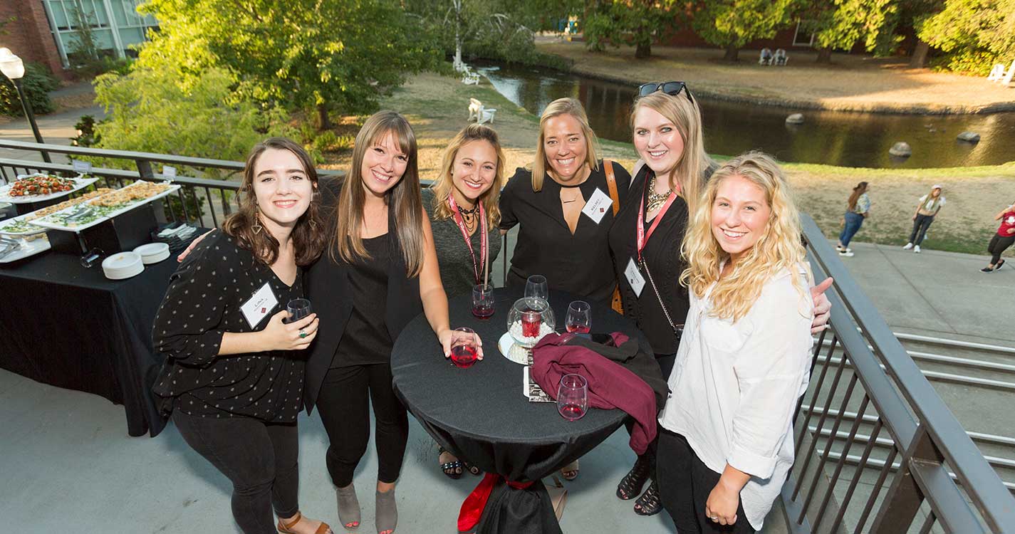 alumni gather on balcony of UC