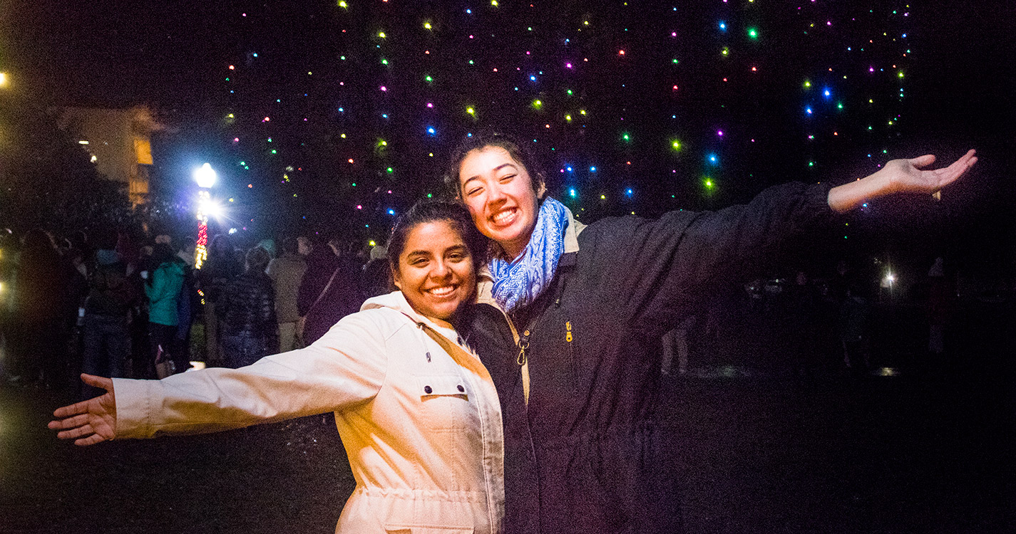 Two students smile before the Star Trees