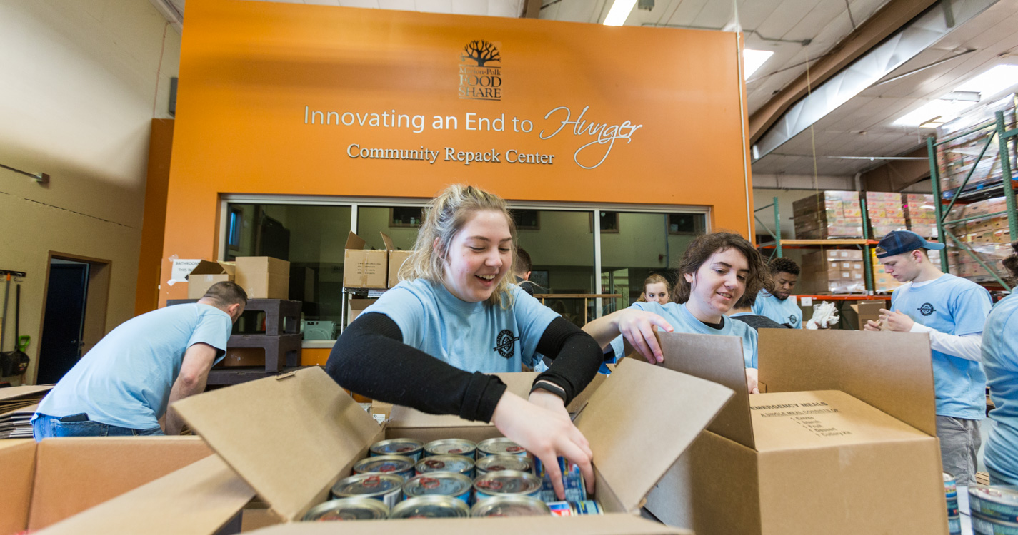 Student packs a box as part of Willamette’s Global Day of Service.