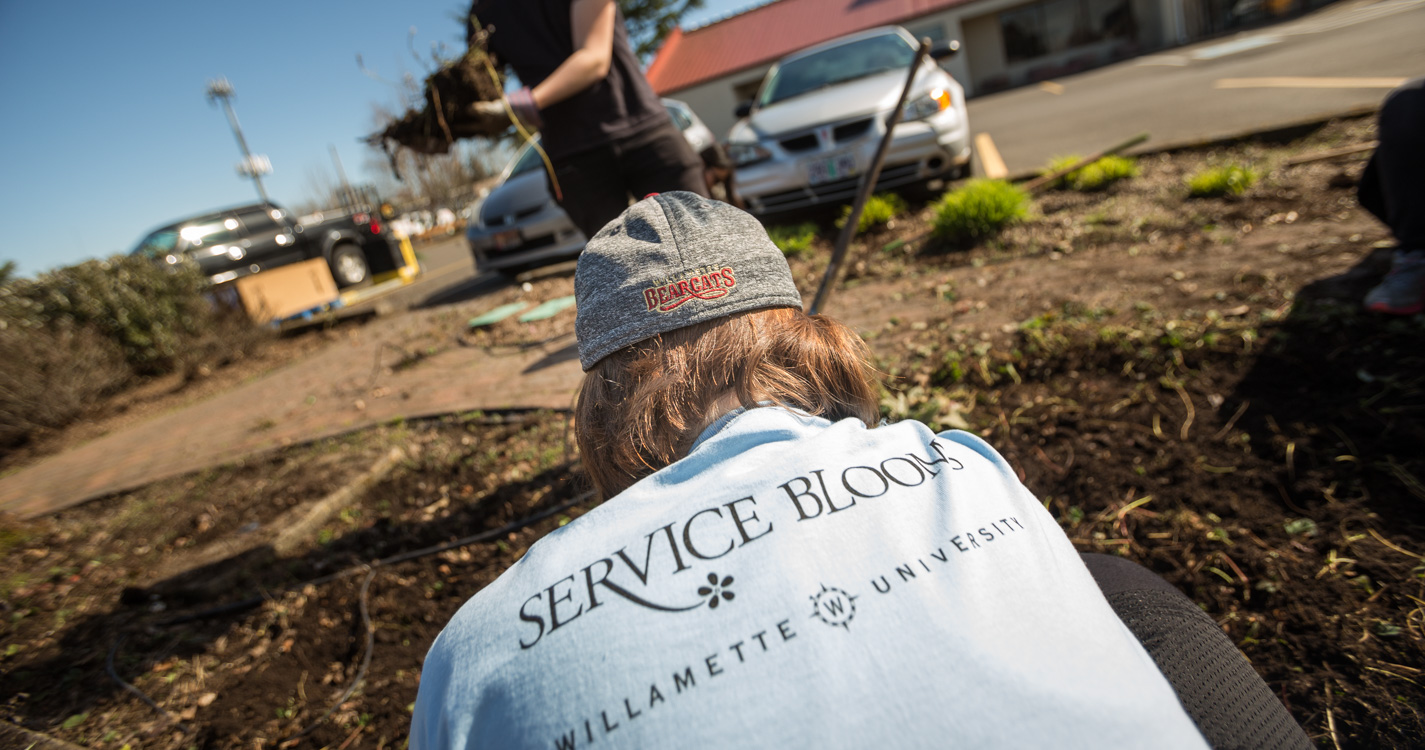 Student shirt says, “Service Blooms Willamette University.” 