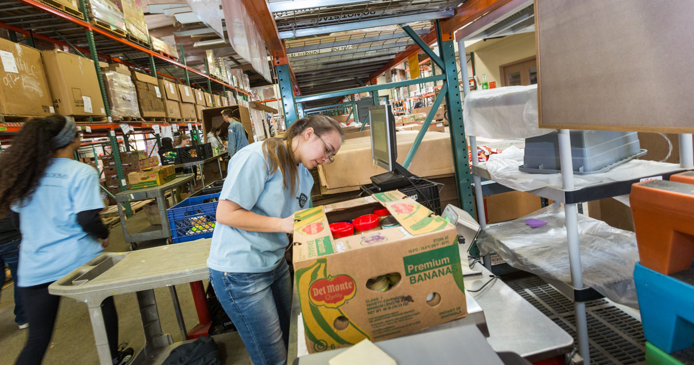 Student packs a box as part of Willamette’s Global Day of Service.