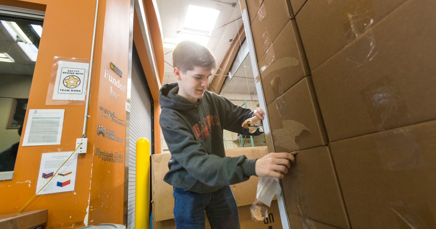 Student packs a box as part of Willamette’s Global Day of Service.