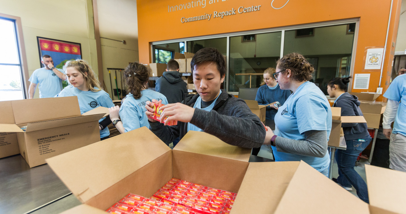 Student packs a box as part of Willamette’s Global Day of Service.