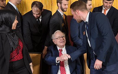 Student from Atkinson Graduate School of Management greets Warren Buffett. Photo by Block 59 Photography