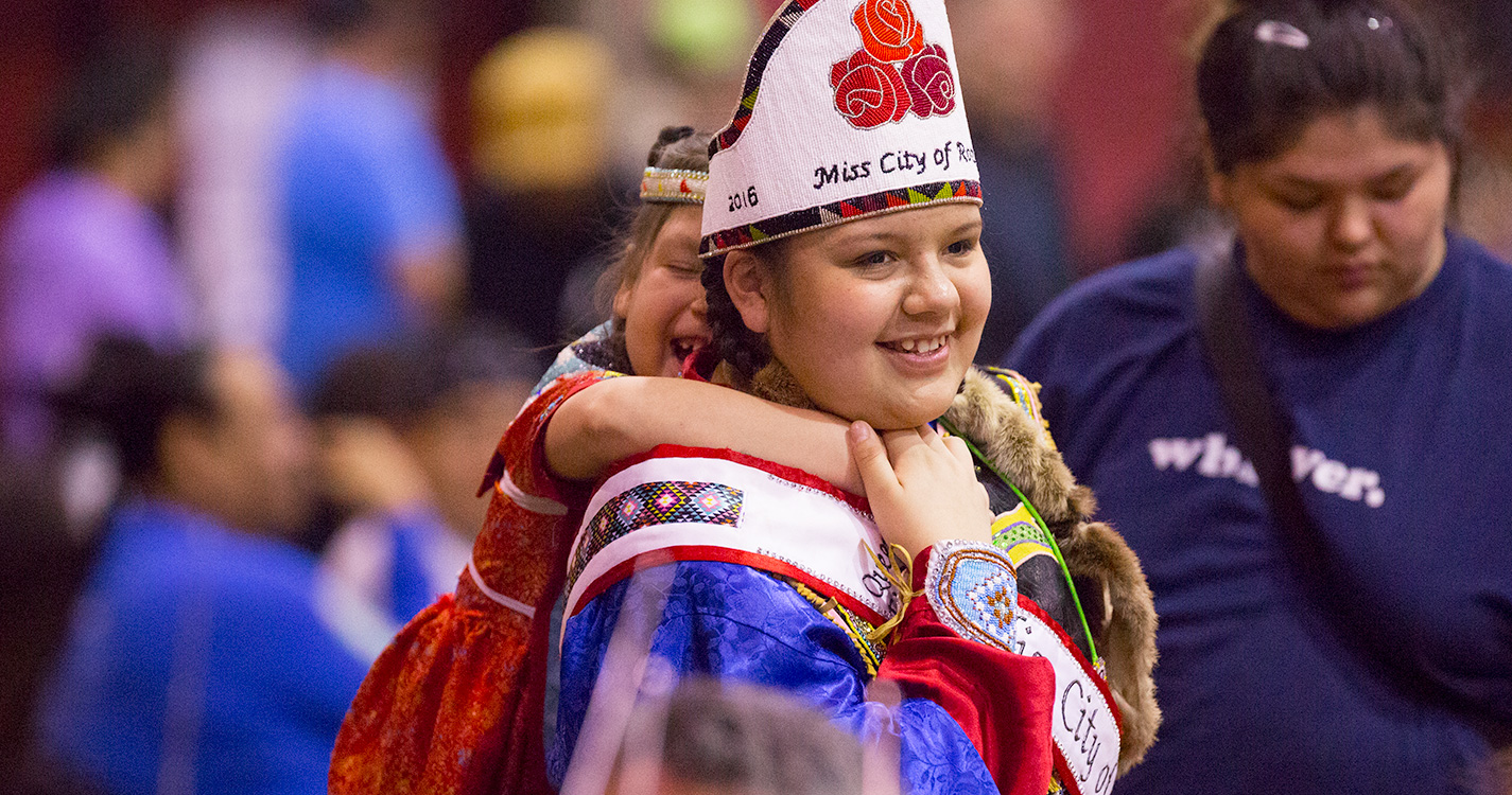 A man is handed some regalia at the Social Pow wow.