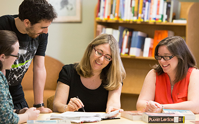 Professor of Law Laura Appleman sits at a table with three students having a discussion