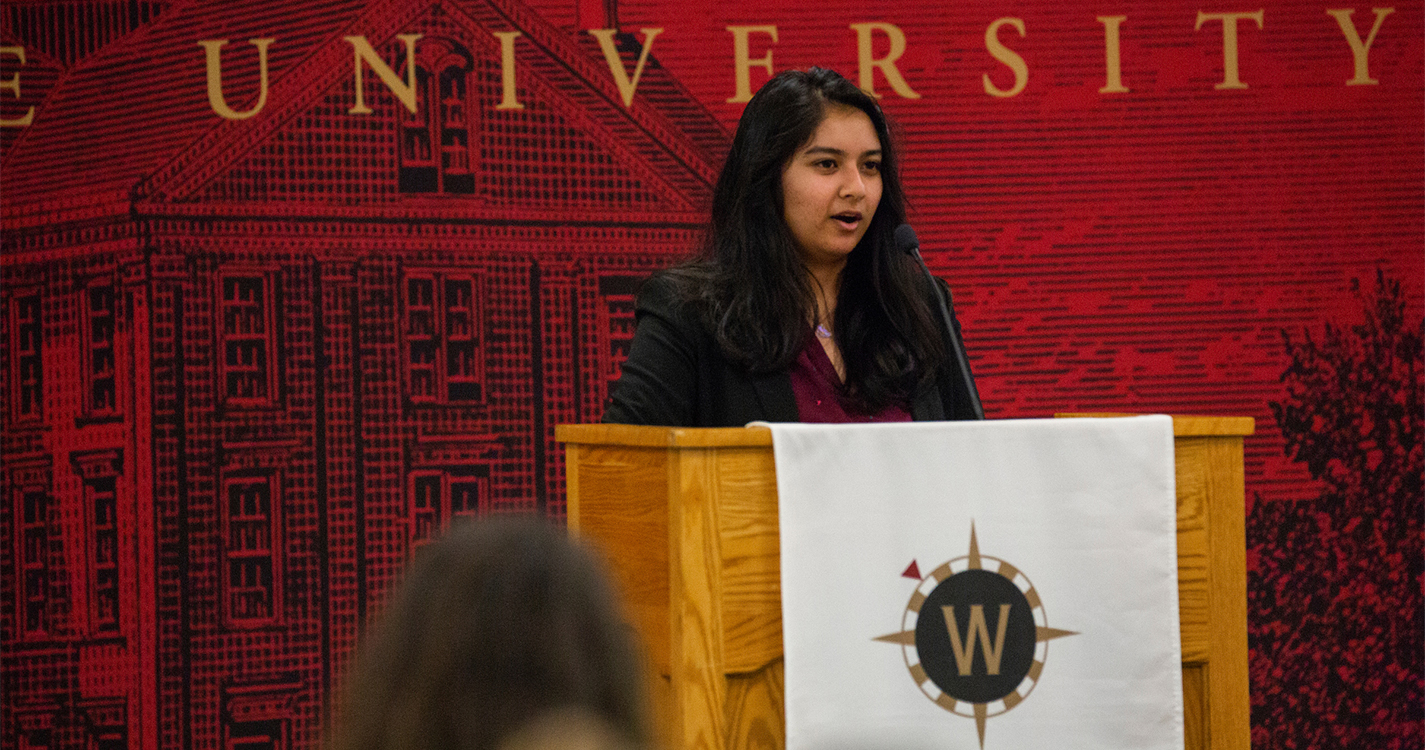 a person speaks from a podium presenting an award