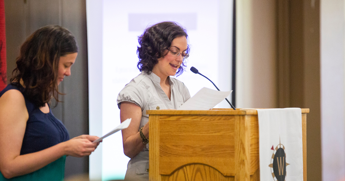 two people speak from a podium presenting an award