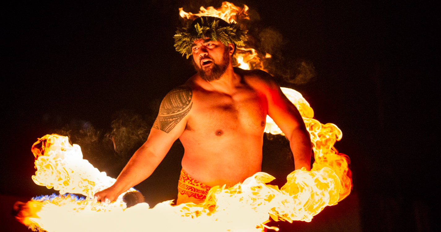 Man twirls fire at luau