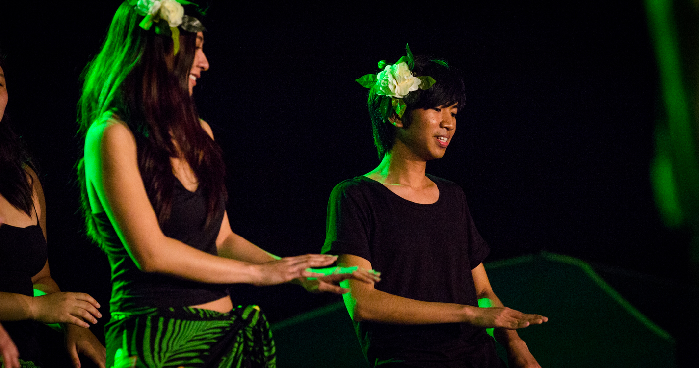 dancers in green light at the luau