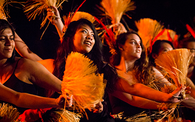 Willamette students dance with fans in the luau