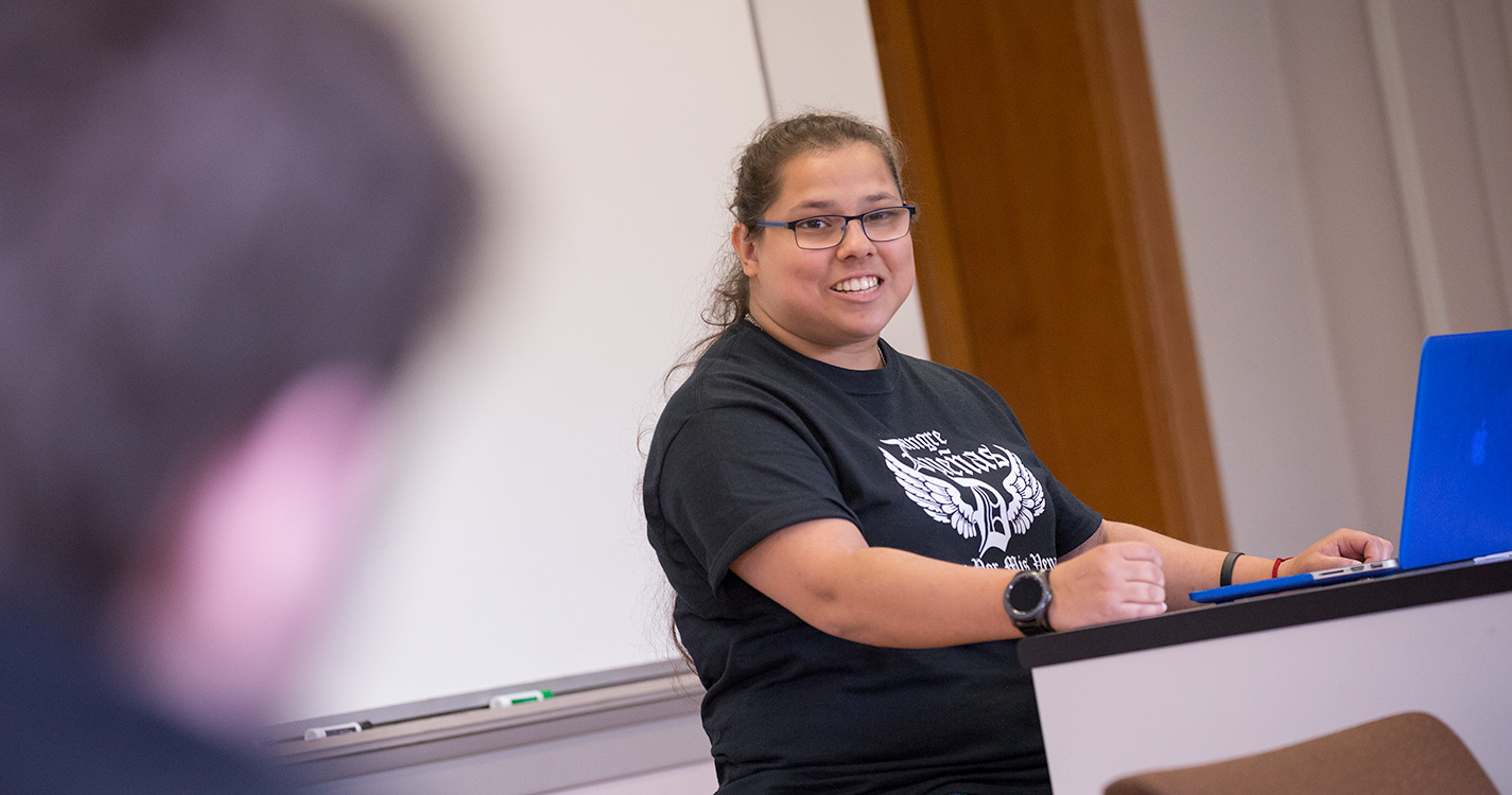 A student at a podium presents research at Student Scholarship Recognition Day. 