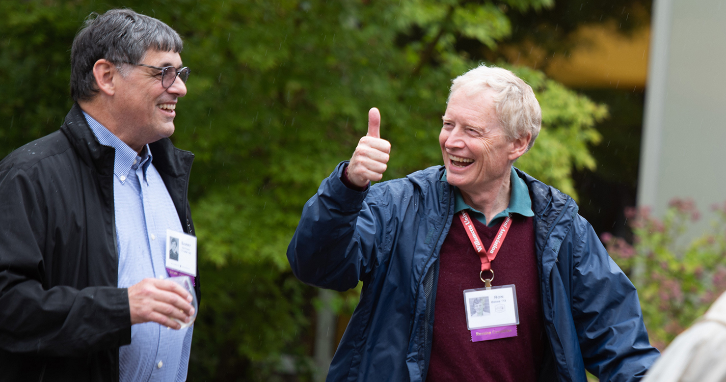 an alumnus gives a thumbs up to another