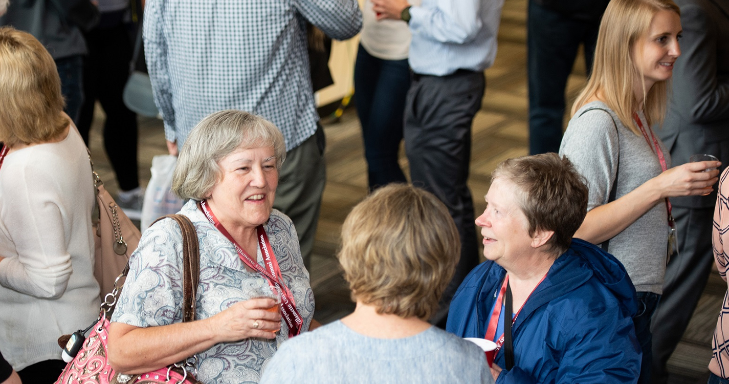 alumni smile and converse in the Montag Center