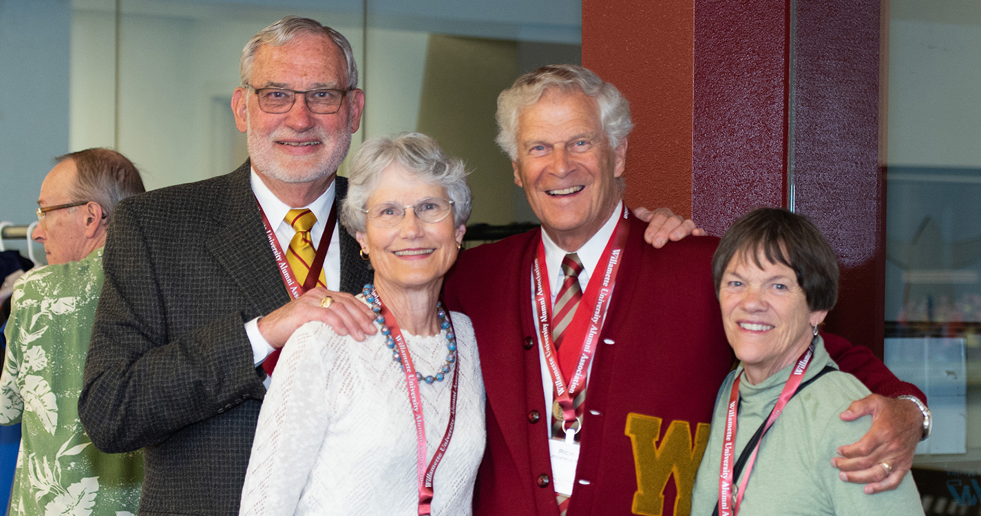 four alumni smile for the camera