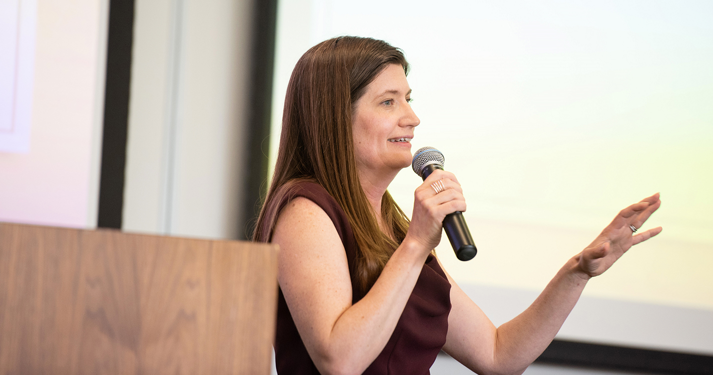 a speaker stands before a crowd 