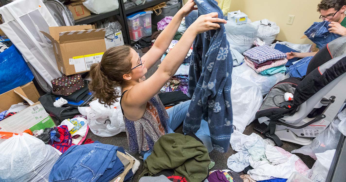 A student sanitizes a toy at the Center for Hope and Safety during Bearcats Give Back