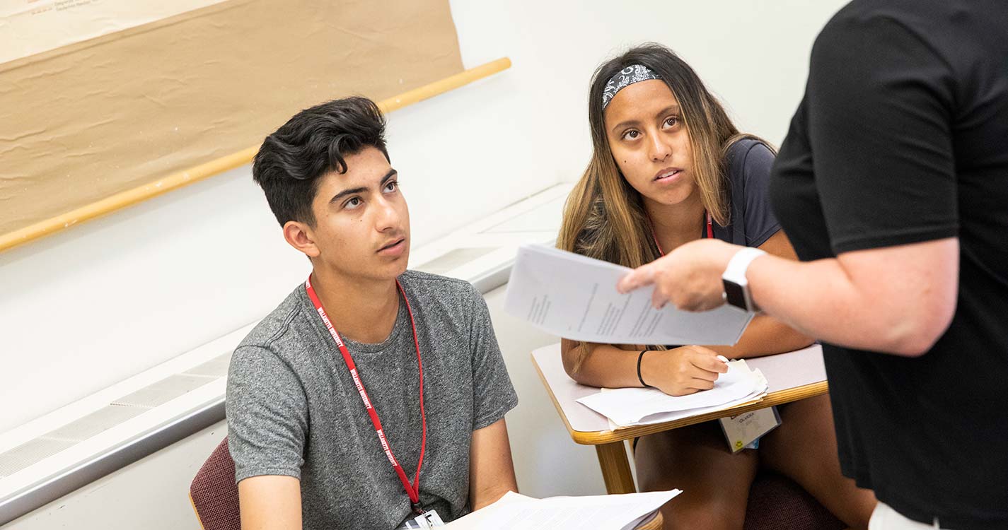 Students at desks looking at professor