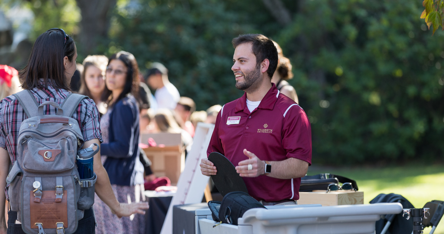 Staff member Mitch Diaz smiles at an expo table