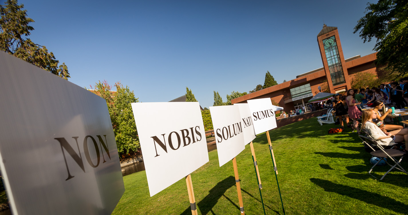 Posters with words Non Nobis Solum Nati Sumus with Jackson Plaza clock tower in background