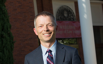 Curtis Bridgeman stands in front of the entrance to Willamette University School of Law