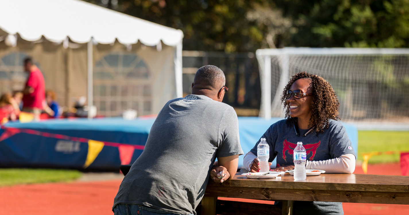 Two people visit at a picnic table