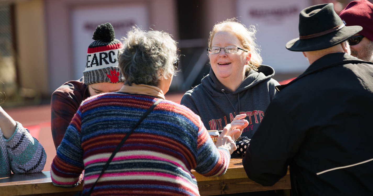 Fans visit while eating at a picnic table