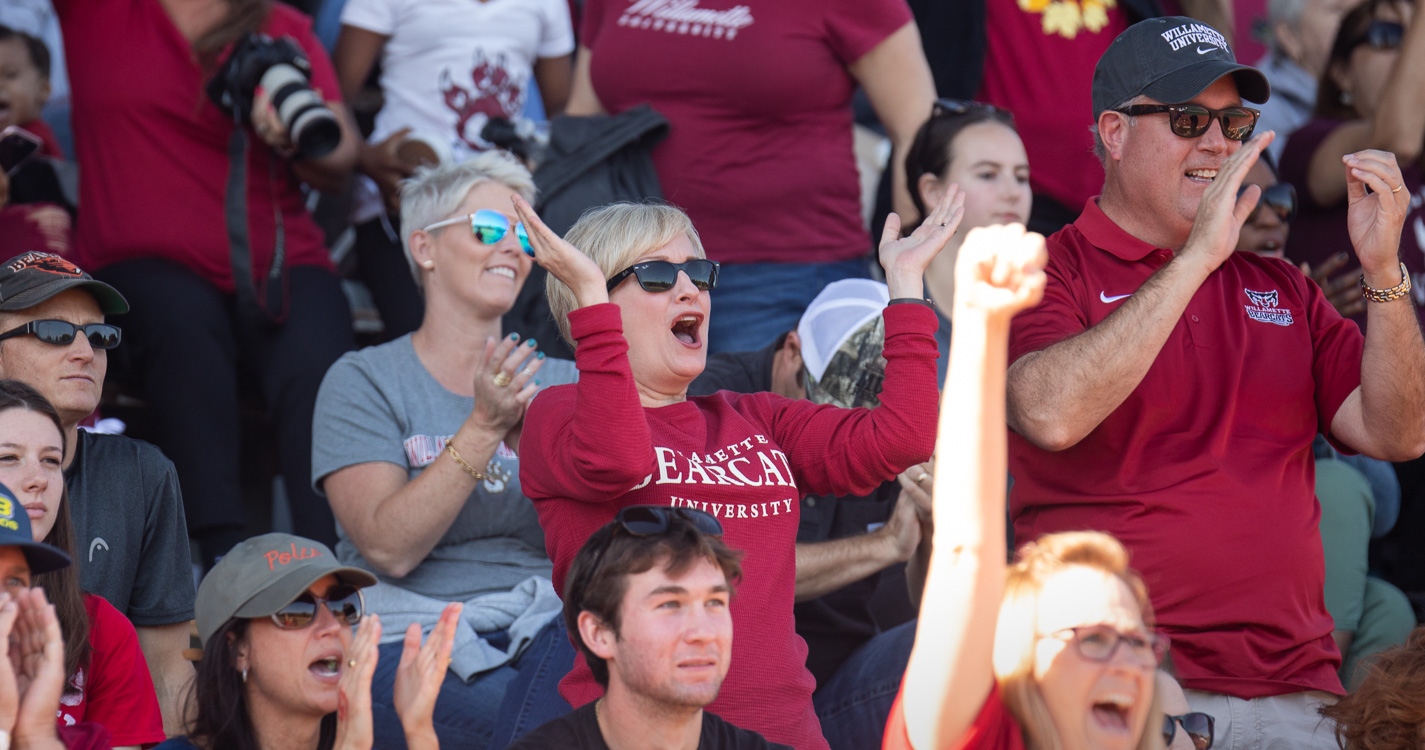 Fans stand in the football stadium cheering