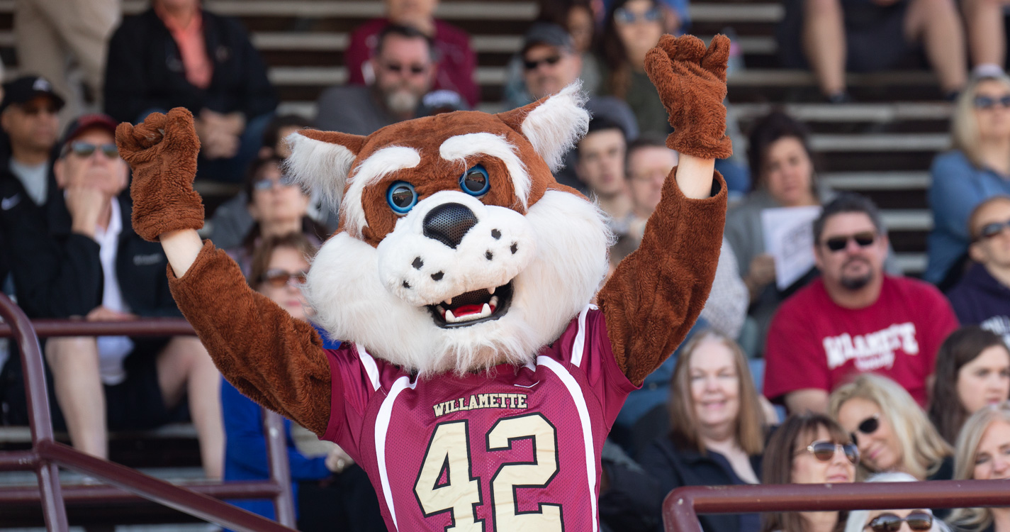 Blitz the Bearcat cheers in front of the stands at a football game