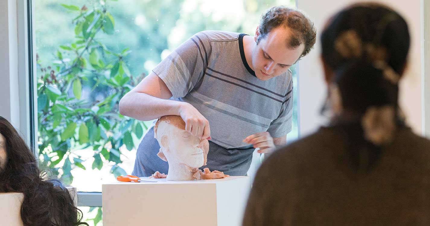 Students show sculpture at art opening.