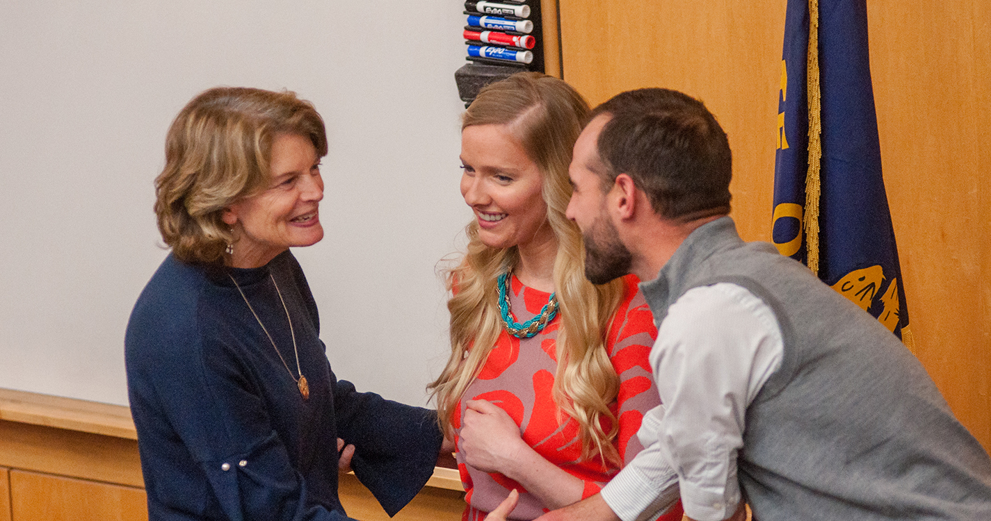 Sen. Lisa Murkowski greets two students with a handshake.