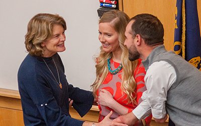 Sen. Lisa Murkowski greets two students with a handshake.