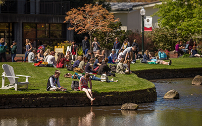 Students hang out along the mill stream