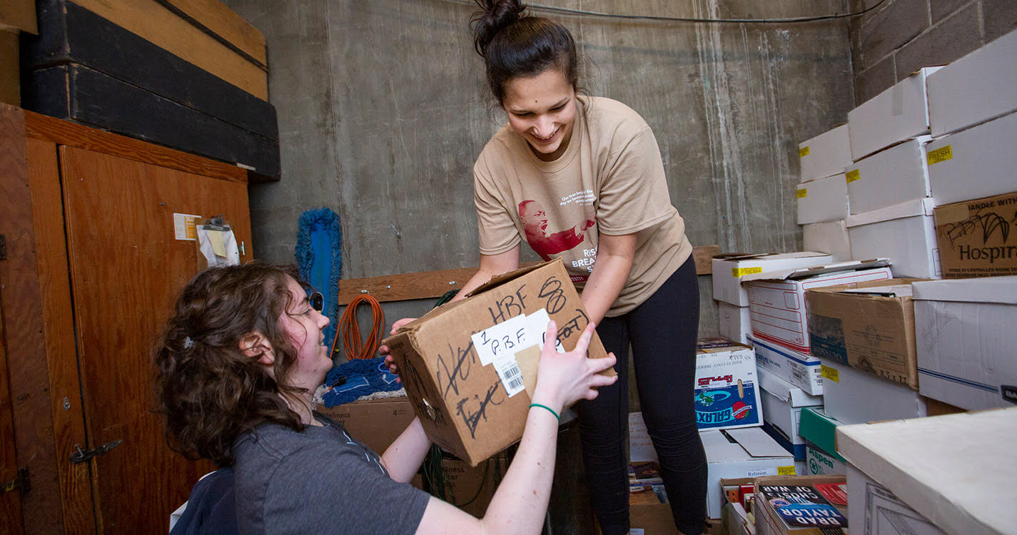 Students move boxes of books 