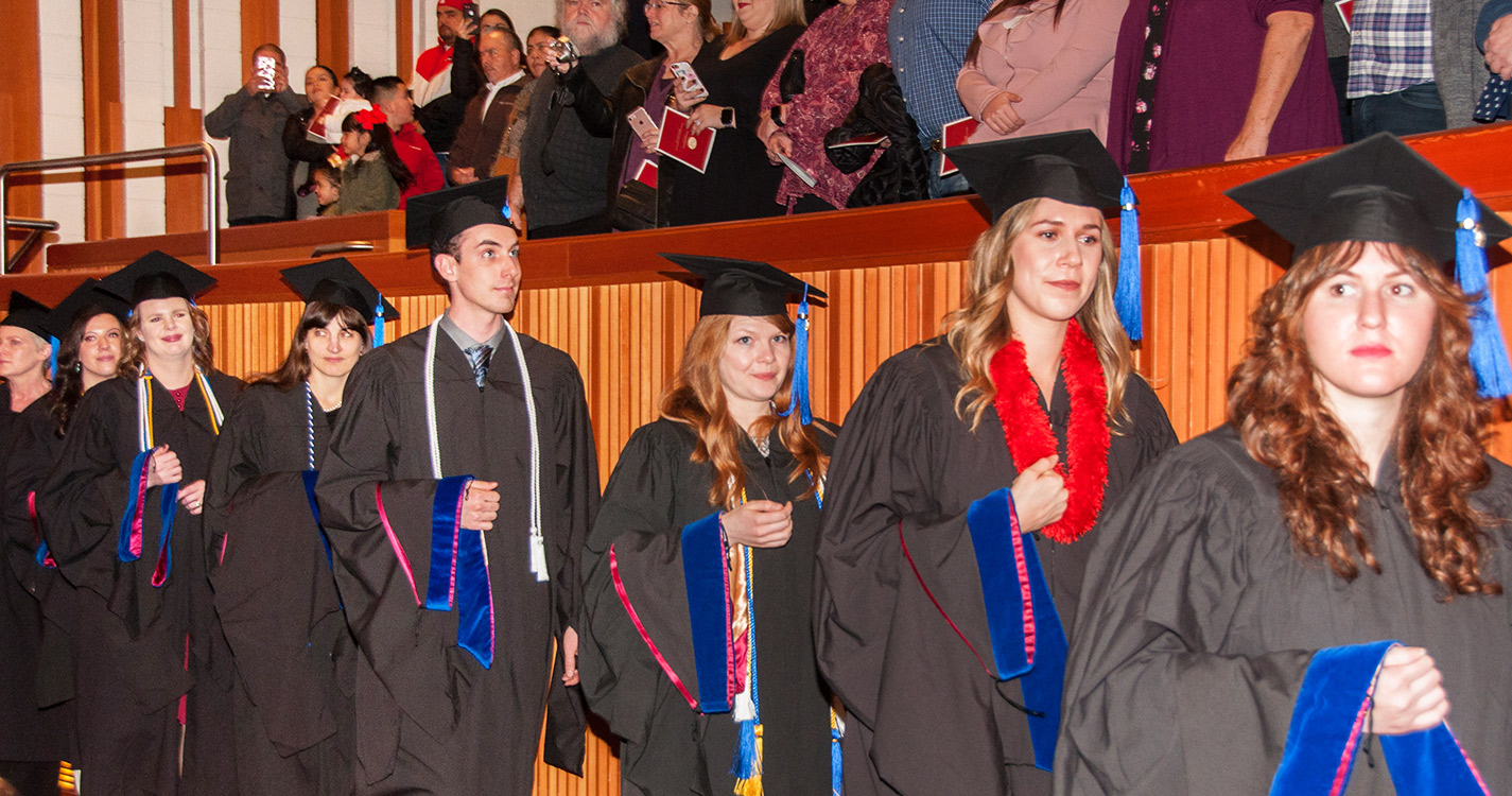 Graduates stand in procession