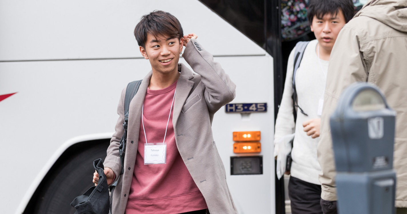 ASP student smiles as disembarking bus