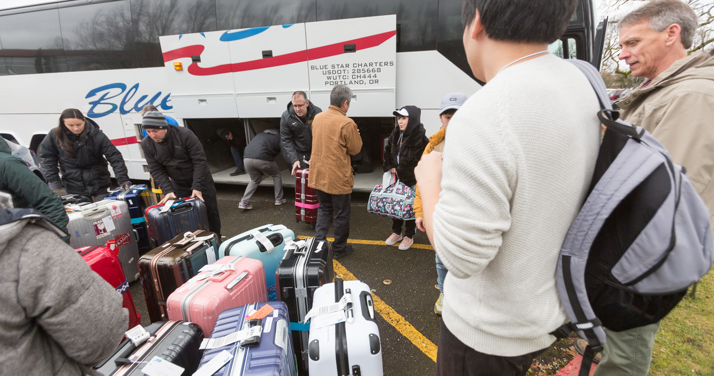 Willamette community members unload baggage from a bus