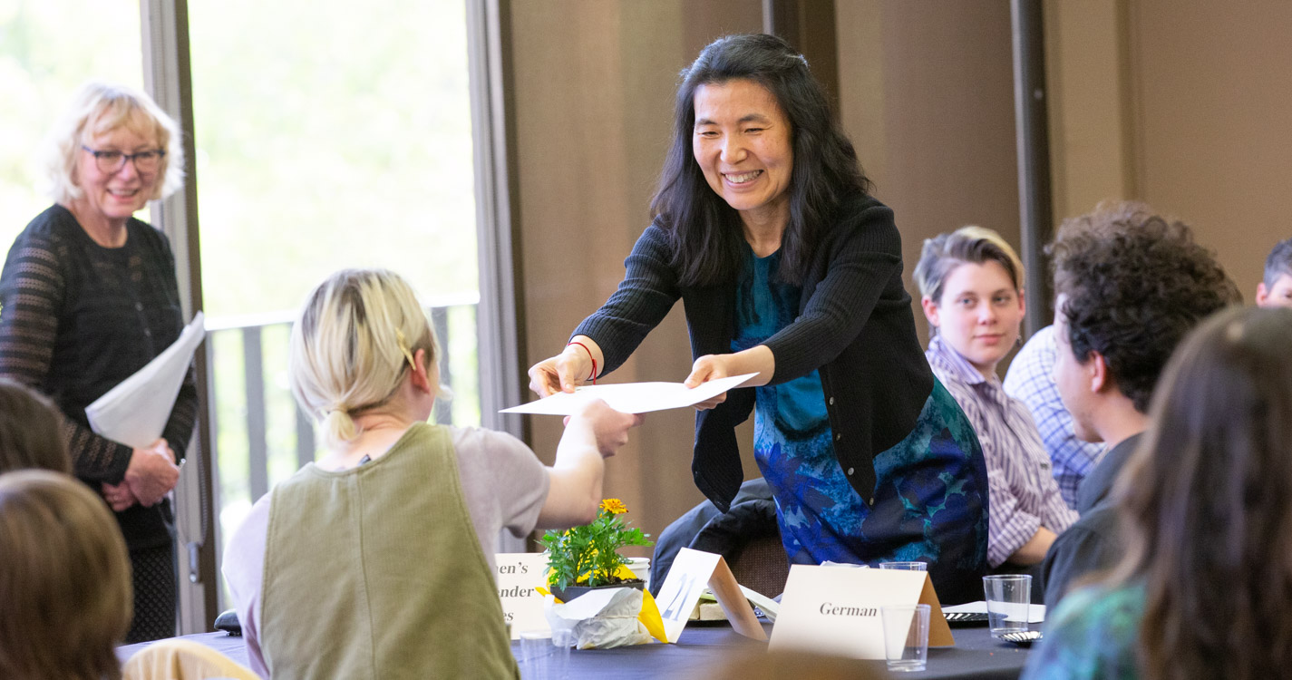 professor presents an award certificate to a student