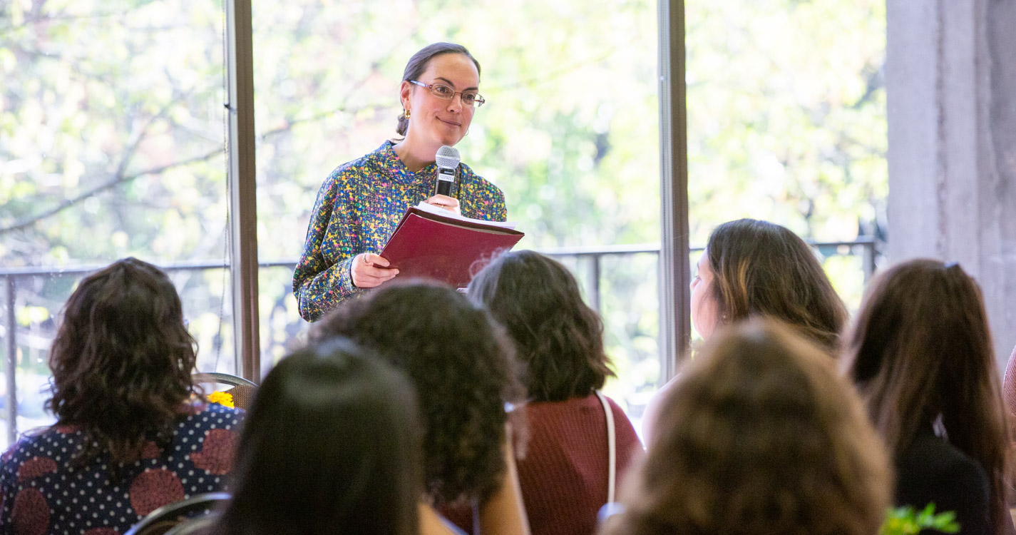 professor reads at a microphone