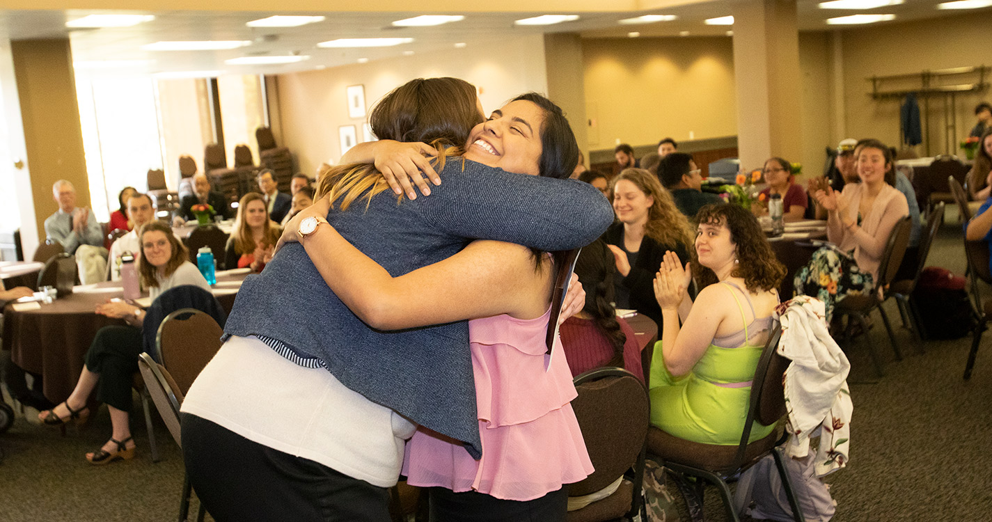 Presenter Claire Leitzen hugs winner Karla Gutierrez-Hernandez ’19 