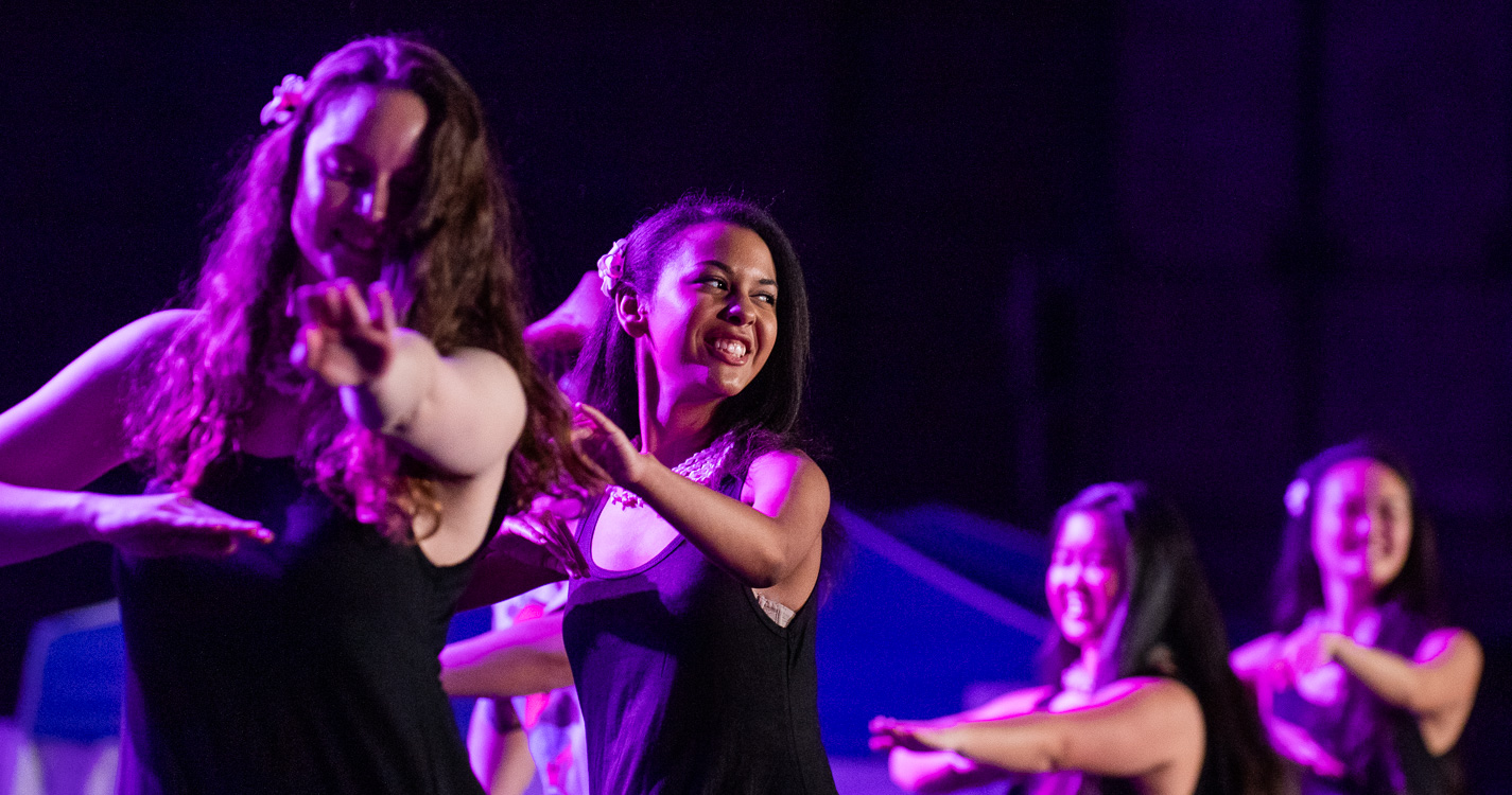 Students dance in a line at the lū’au