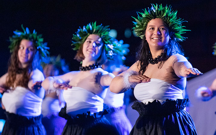 Students in straw hats dancing