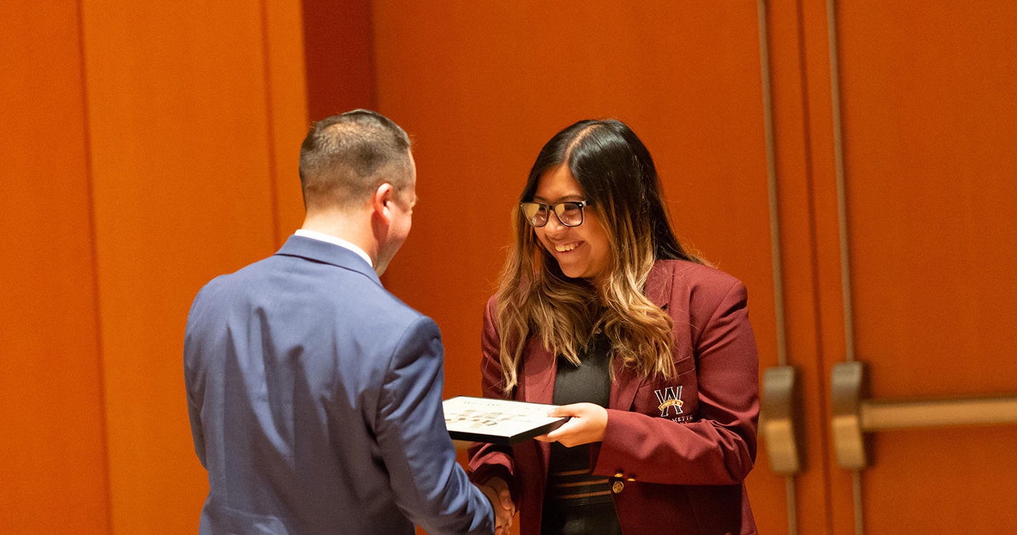 student receives certificate from Executive Director Emilio Solano 