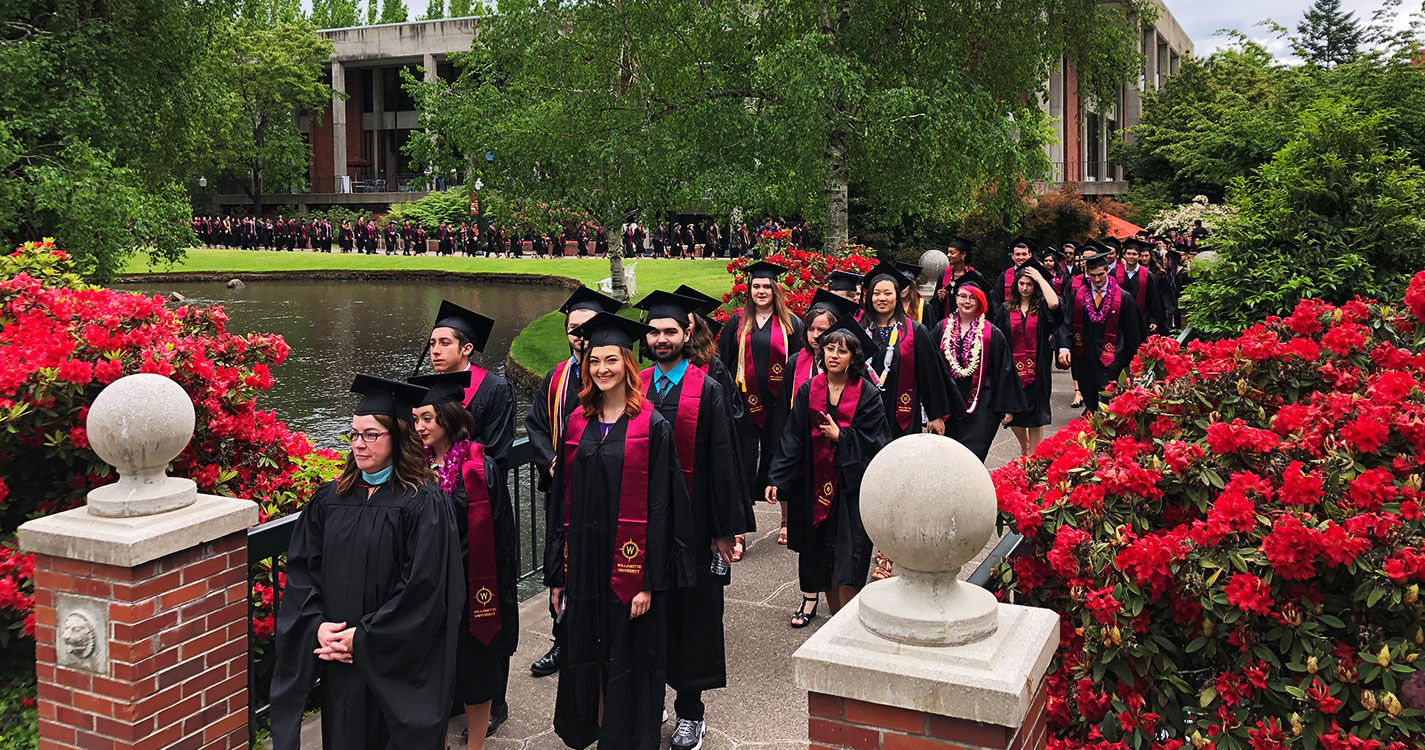 CLA graduates wearing regalia in procession around the Mill Stream