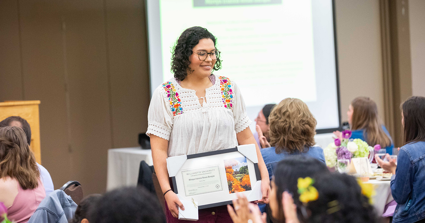 Student stands after receiving award