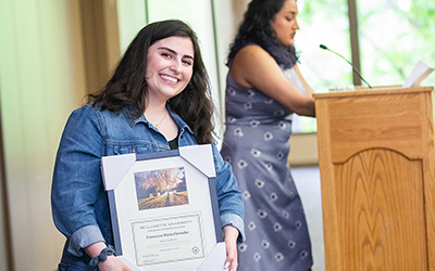 student smile with award in hand