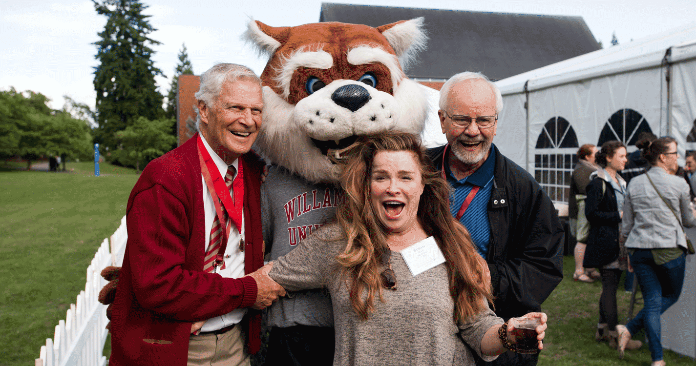 three alumni pose with Blitz the Bearcat on the quad.