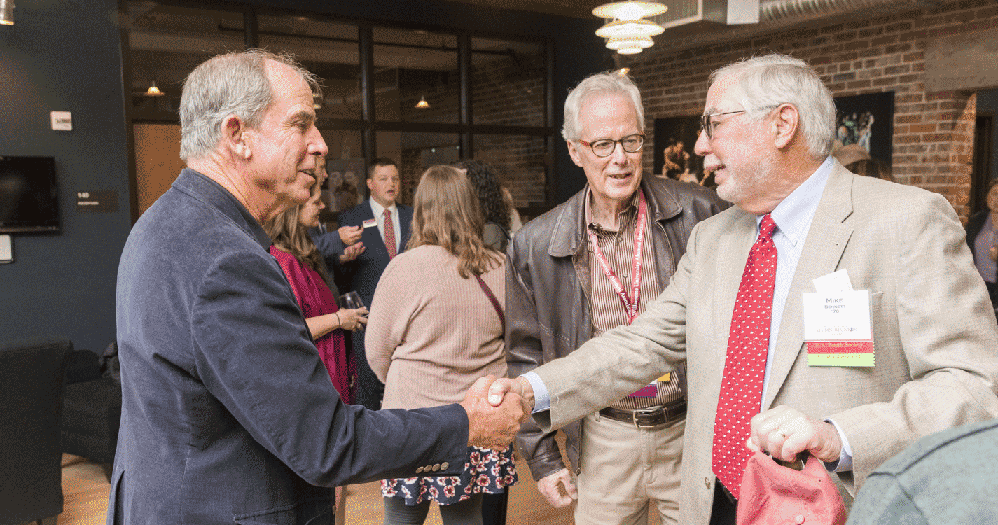 A group of alumni chat at the awards dinner