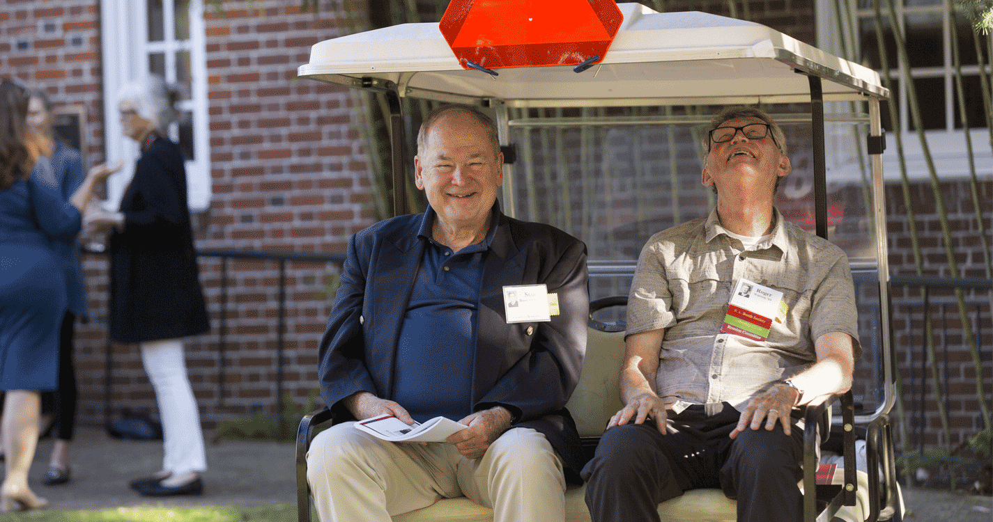 Two Bearcats on a golf cart